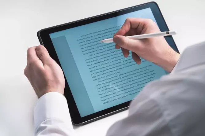 Man writing a book on a tablet
